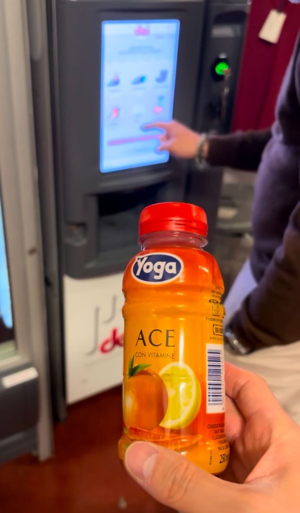 Daniele Fiesoli本社で出されたイタリア産『Yoga ACE』ジュース。自動販売機の前で手に持たれたビタミンたっぷりのドリンク。