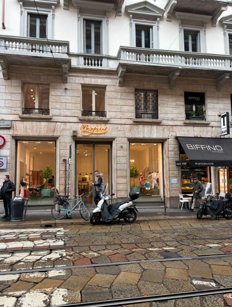 ミラノ中心街にあるイタリア高級レディースファッションブランド『Baypoint』の路面ブティック外観。石畳の美しい通りに面し、上質なヨーロッパブランドらしいディスプレイが印象的。