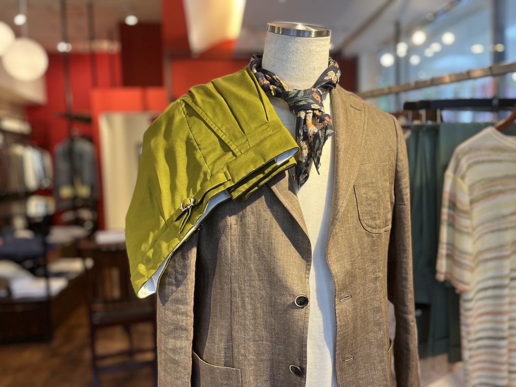 ロベルト・コリーナのグリーンのハーフパンツを肩掛けしたリネンジャケットスタイルのマネキン