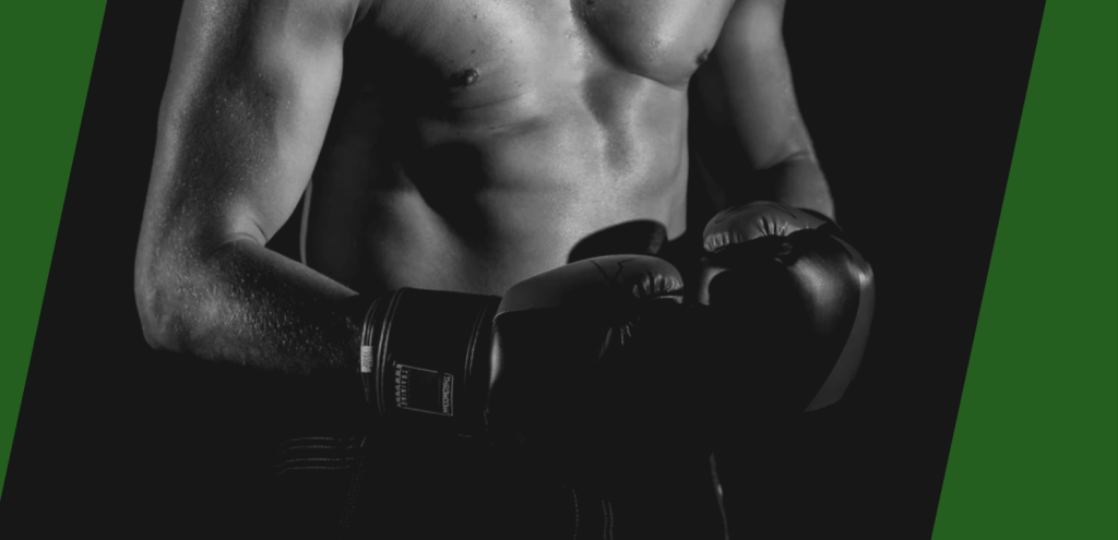 ボクシンググローブをはめ、静かに目を伏せて構える上半身裸の男性ボクサー