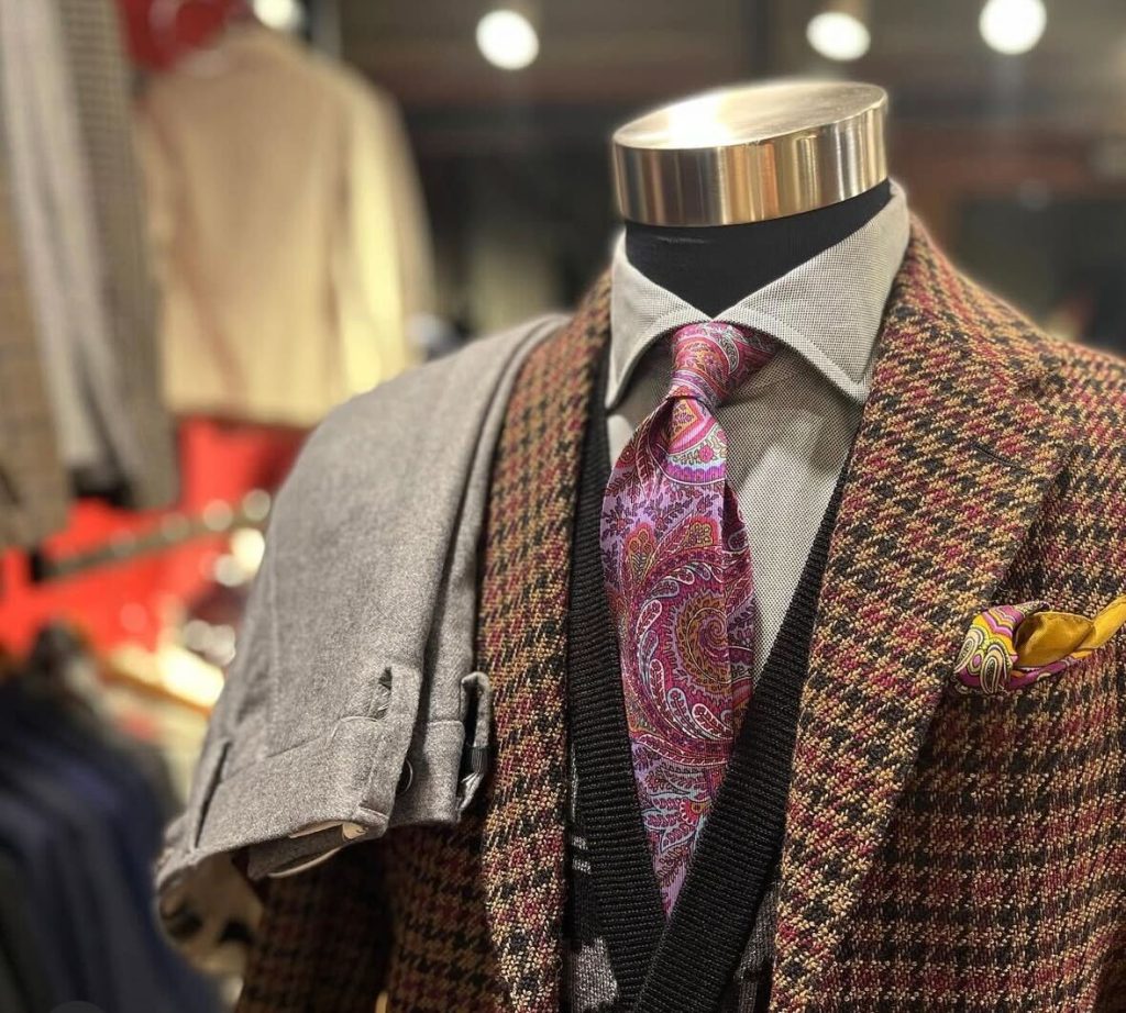 ETRO(エトロ)の千鳥格子ジャケットにパープルのペイズリーネクタイとイエローのチーフを合わせた、クラシックかつ華やかな装いのトルソー