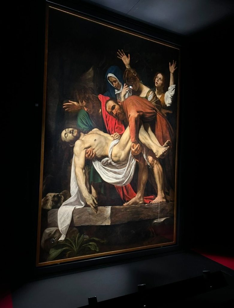 大阪・関西万博のバチカン館で展示されているカラヴァッジョ作『キリストの埋葬』。バロックの巨匠が描いた荘厳な構図と光と影のコントラストが印象的な名画