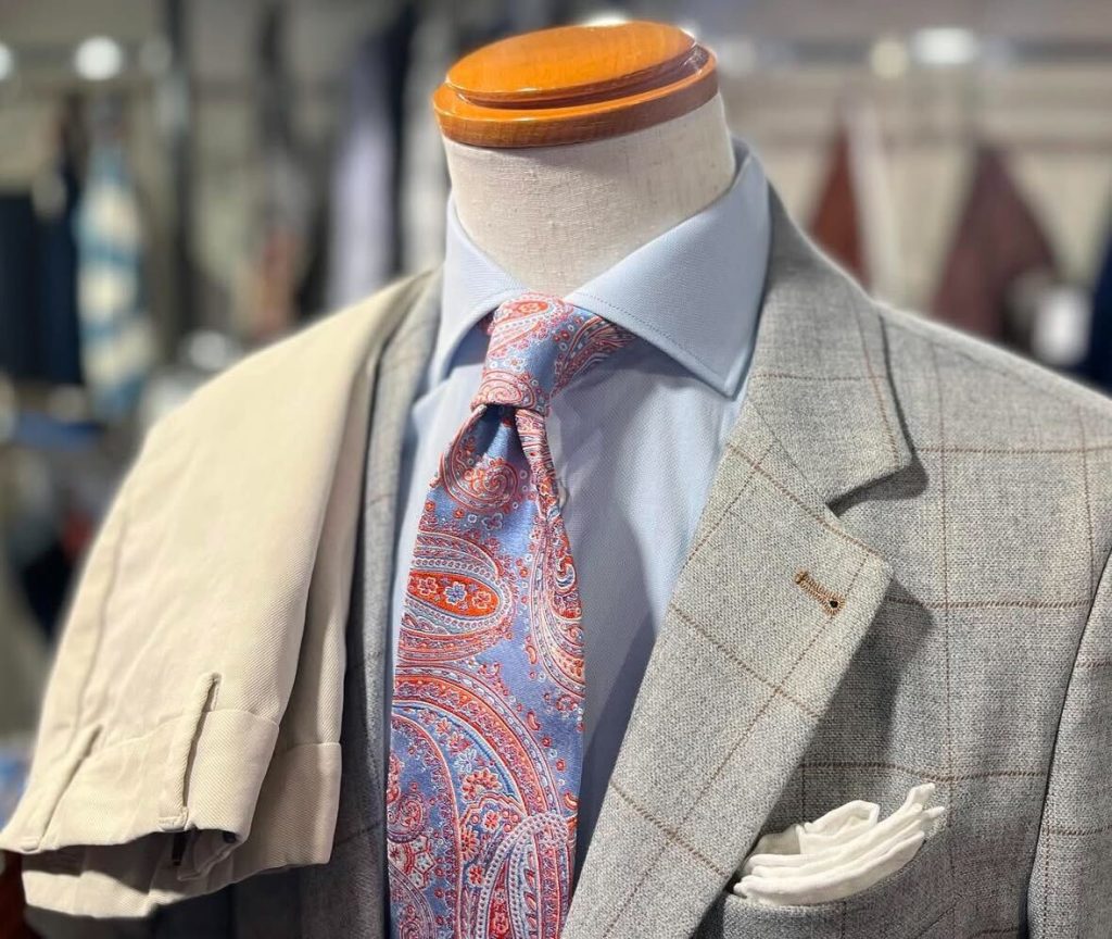 ETRO(エトロ)のグレーのウィンドウペンジャケットに、水色のシャツとブルー×オレンジのペイズリーネクタイを合わせた上品なスタイリング