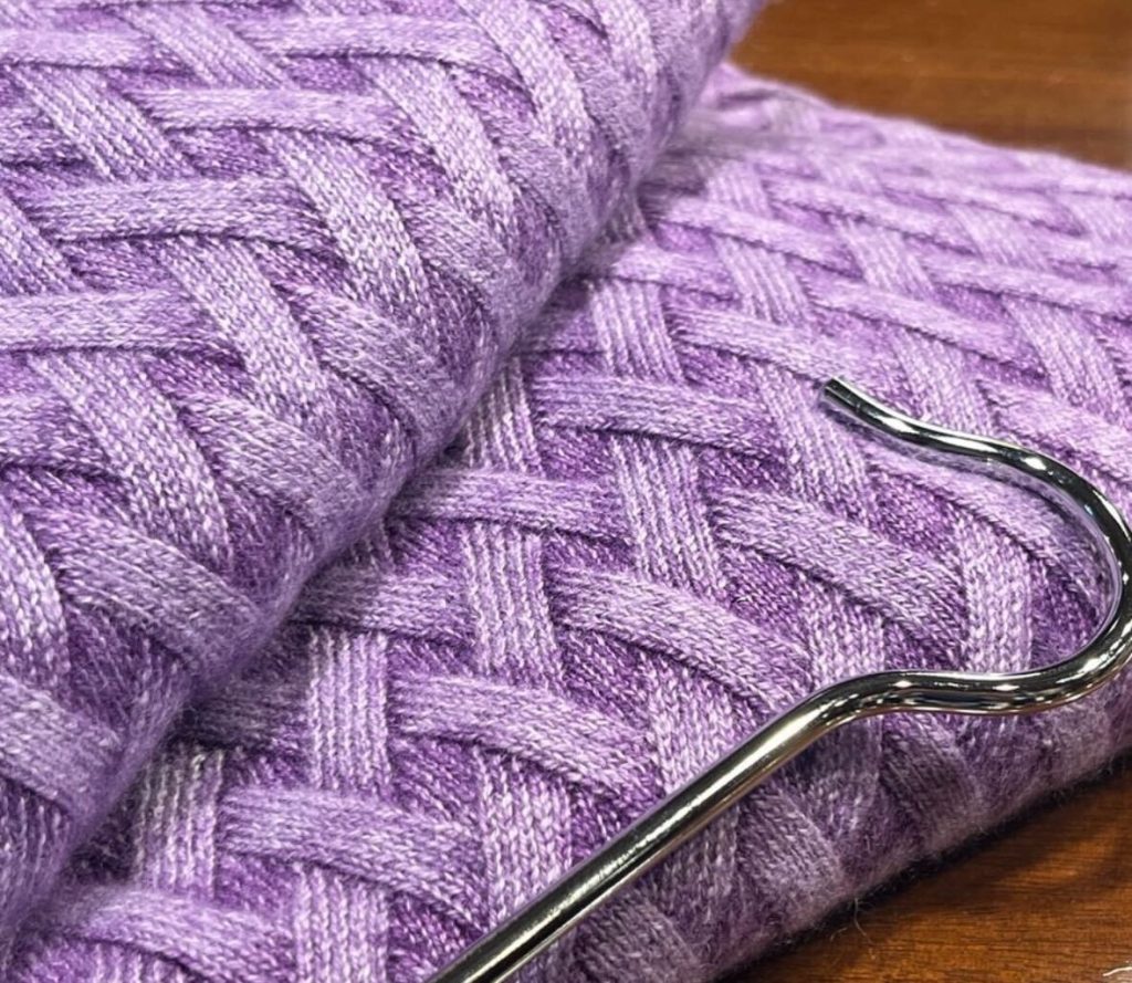 ラベンダーカラーのニット素材の編み目ディテール。ふんわりとした編地が春らしい軽やかさを演出。