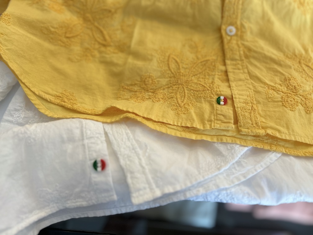 Poggianti1958の刺繍シャツの裾部分。イタリア国旗カラーの飾りボタンがアクセントになっている。