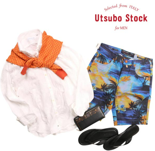 白地に繊細な刺繍が施されたPOGGIANTI1958の長袖シャツ。オレンジの柄ニットを肩掛けし、南国柄のショートパンツとサンダルを合わせたリゾート感あふれるコーディネート。