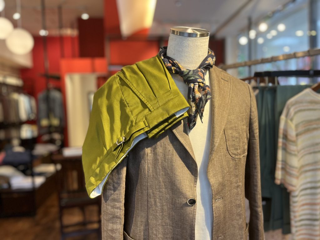 ドレープ感のあるロベルト・コリーナのオリーブグリーンのハーフパンツを壁にかけた様子