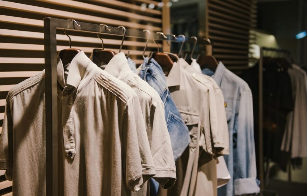 ベージュやデニムのシャツが並ぶショップのラック。服を選ぶ行為の「選択」と「美意識」を象徴。
