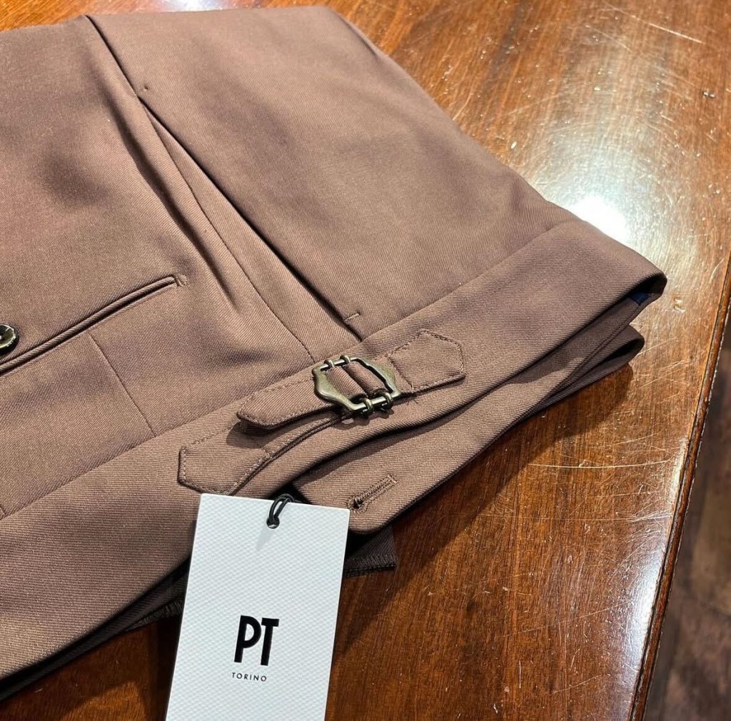 PT TORINOのクラシックなスラックス。ベルトレス仕様で、両脇に真鍮色のサイドアジャスターを備えたディテールが特徴。