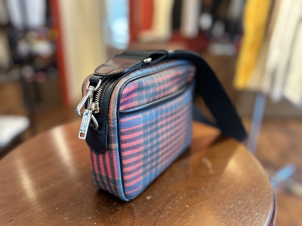 ETROのボディバッグを横から見た写真。ファスナーやロゴ入りメタルパーツが際立つ