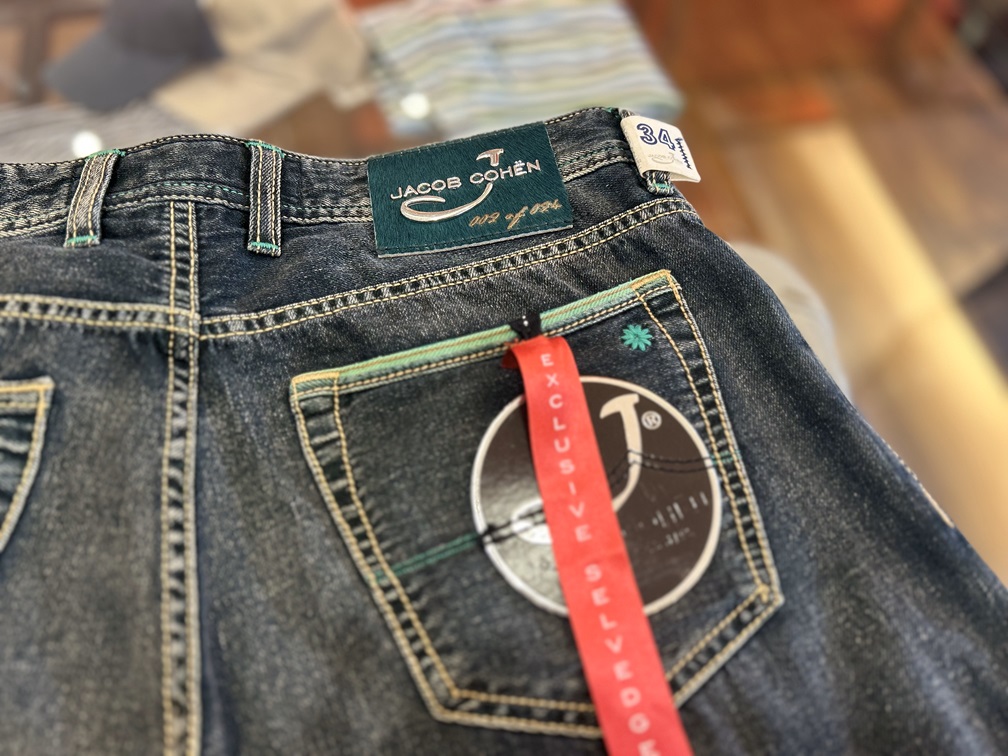 JACOB COHENのデニムパンツ背面と緑のパッチ、限定タグ付きの全体像