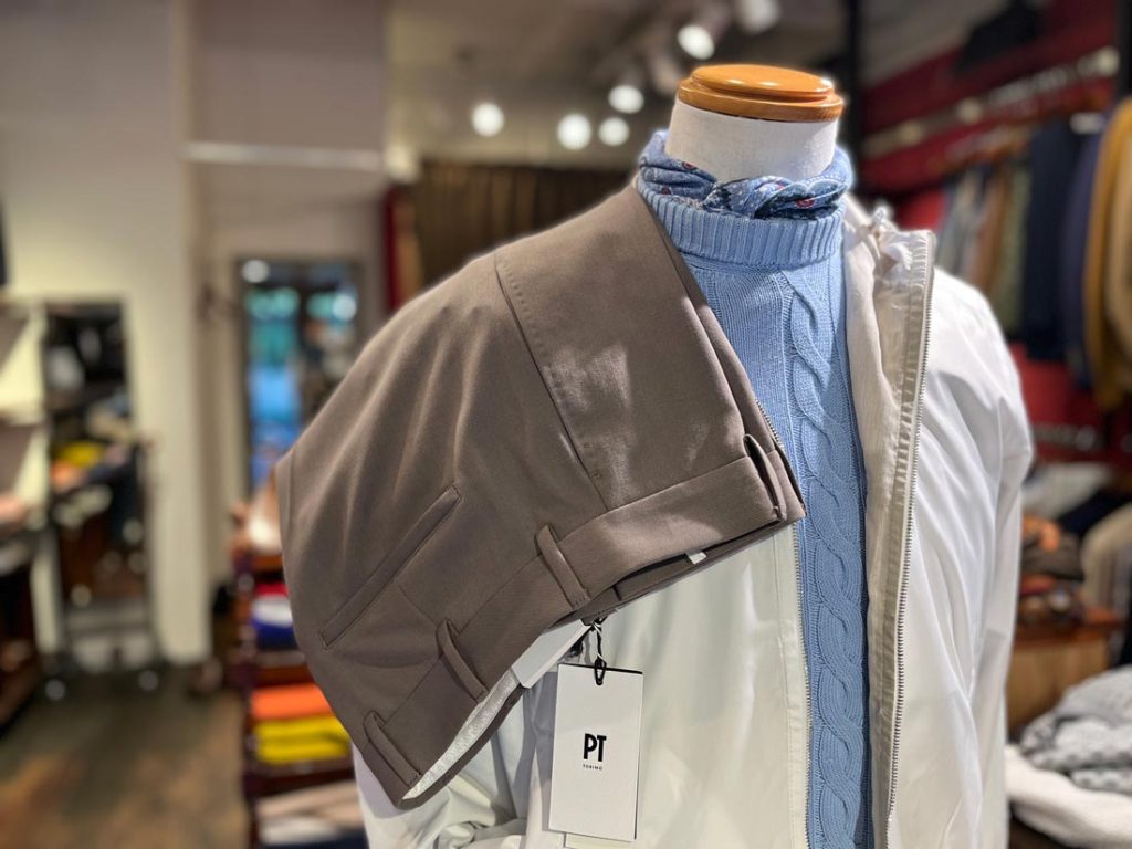 スカイブルーのネッカチーフとニットが同系色で馴染んだスタイリング。