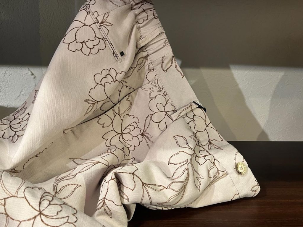 OUTFITのフラワープリントショーツ。ベージュの生地にブラウンの繊細な花柄があしらわれた、夏にぴったりの上品なリゾートスタイル。