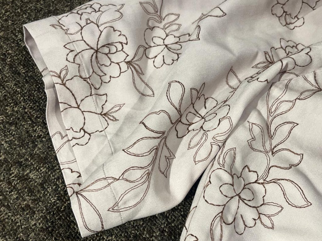 OUTFITのショーツ裾部分。繊細なラインで描かれた花柄が、動きのある表情を演出。軽快さとエレガンスを両立したデザイン。