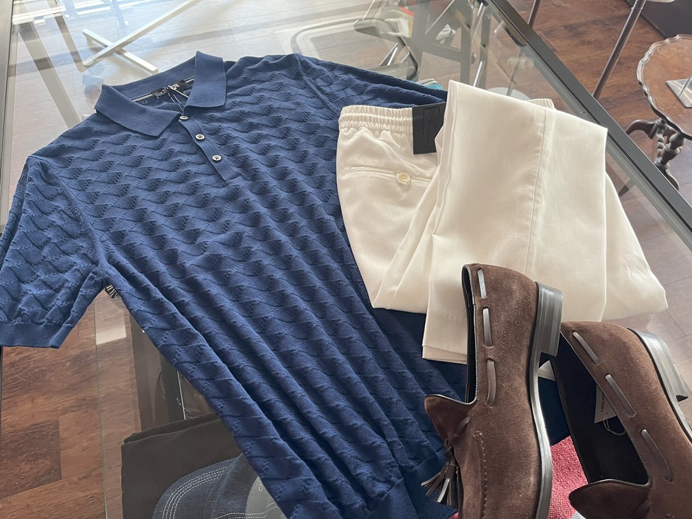 ブルーのポロシャツに白パンツとブラウンローファーを合わせた清潔感あるコーディネート。