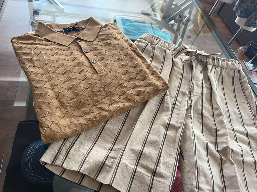 ブラウンのポロシャツにストライプ柄のリラックスパンツを合わせた大人のリゾートスタイル。