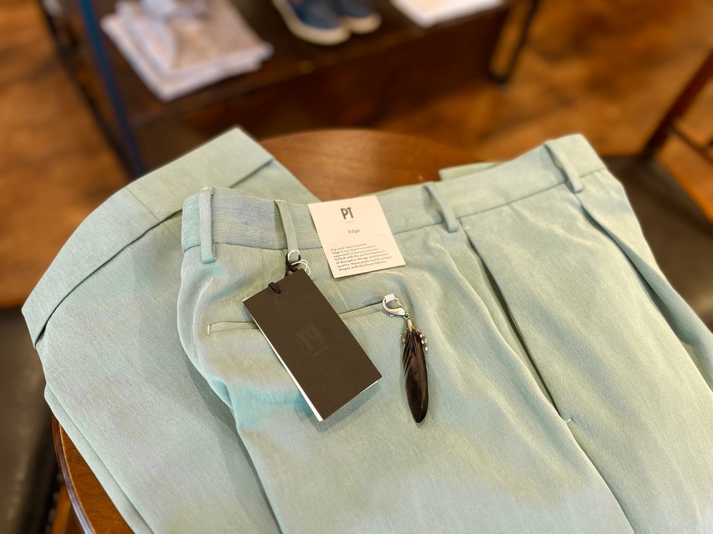 PT TORINO Edgeのライトグリーンパンツを平置きで撮影。フェザー付きタグも添えられている。