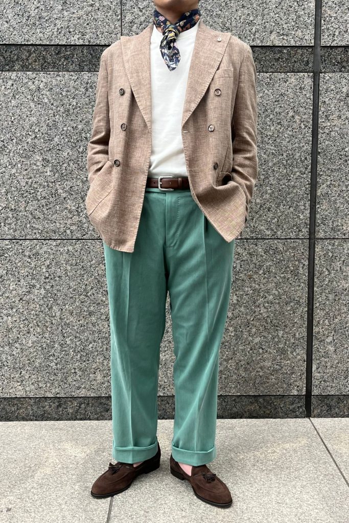 ライトグリーンパンツを使用した着用スタイル。白Tシャツとブラウンジャケットの組み合わせで都会的に。
