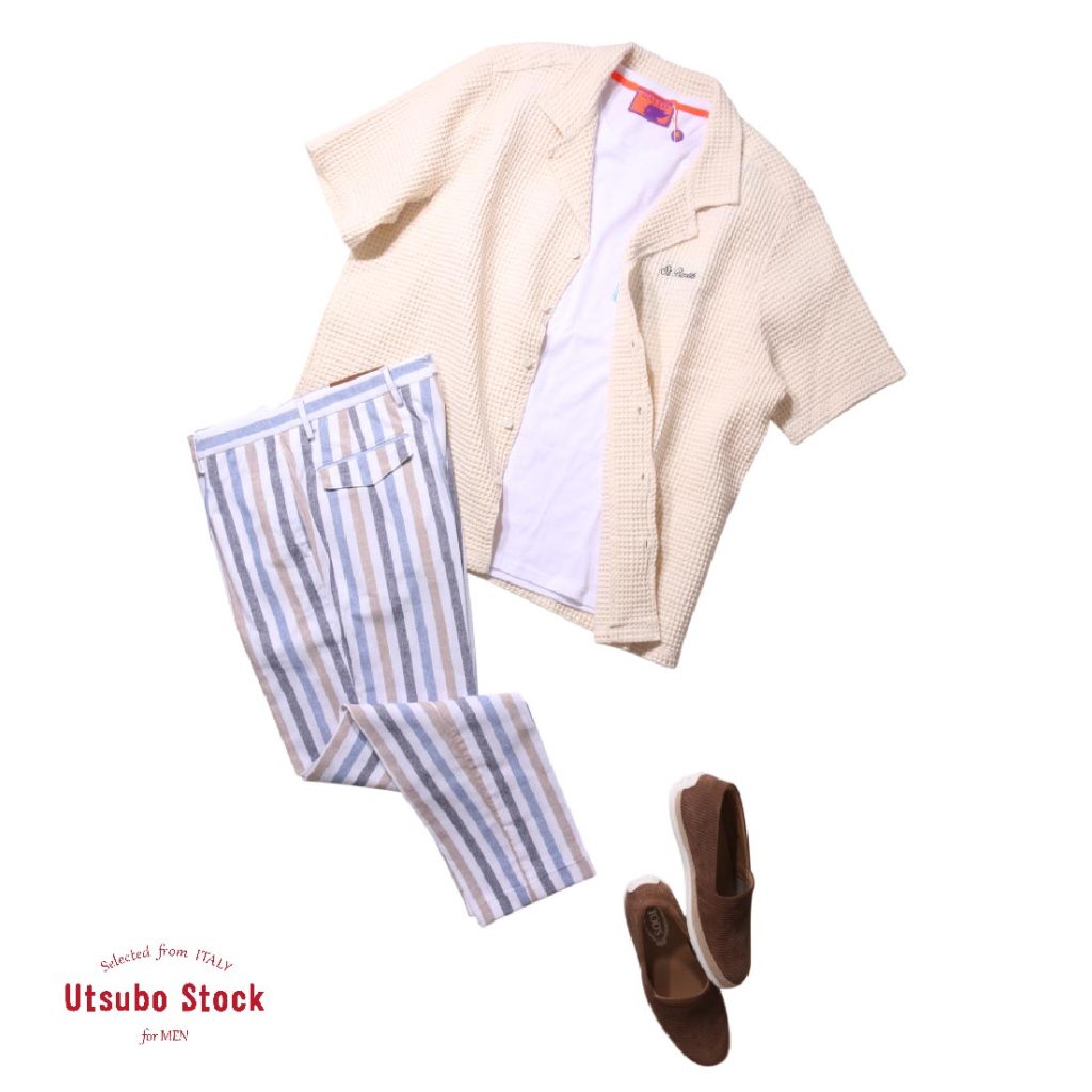 ベージュの半袖シャツと白Tシャツに、ブルーとベージュのストライプパンツを組み合わせた爽やかな夏のセットアップスタイル。足元にはブラウンのスリッポンを合わせ、リゾート感のある抜け感を演出。