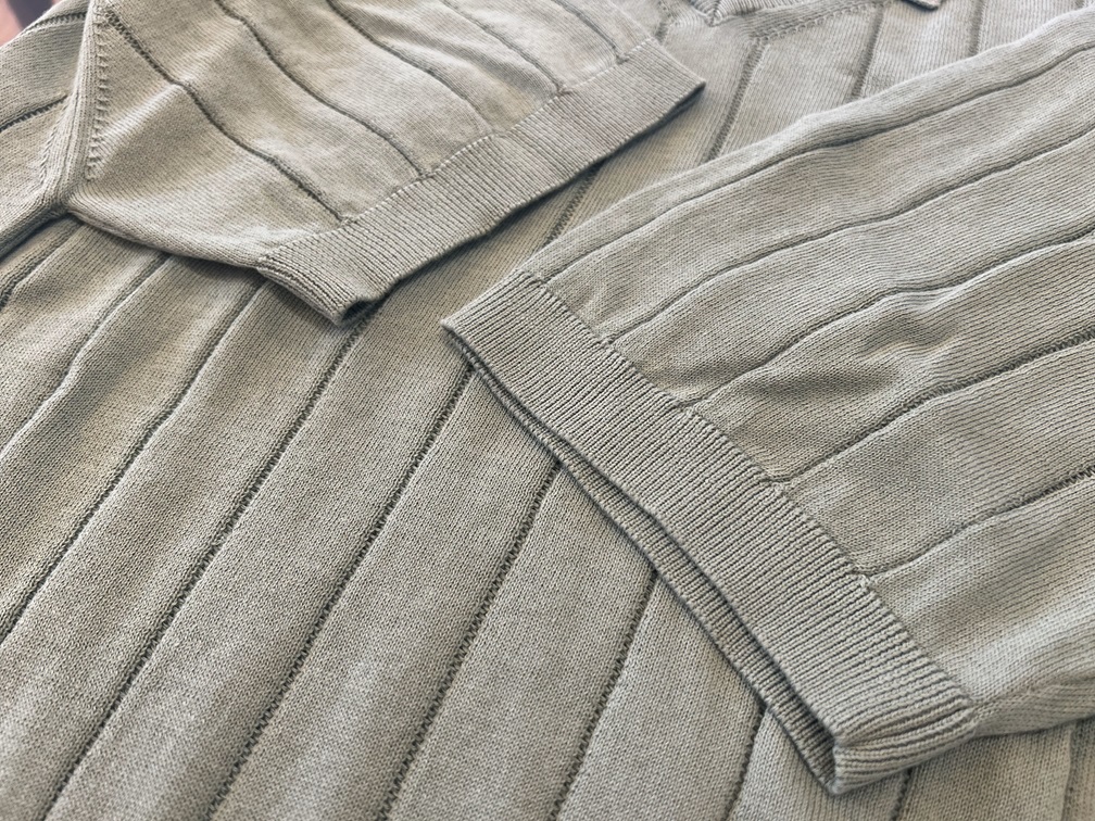 袖と裾の編み込みディテールが際立つTAGLIATOREのスキッパーニットの質感