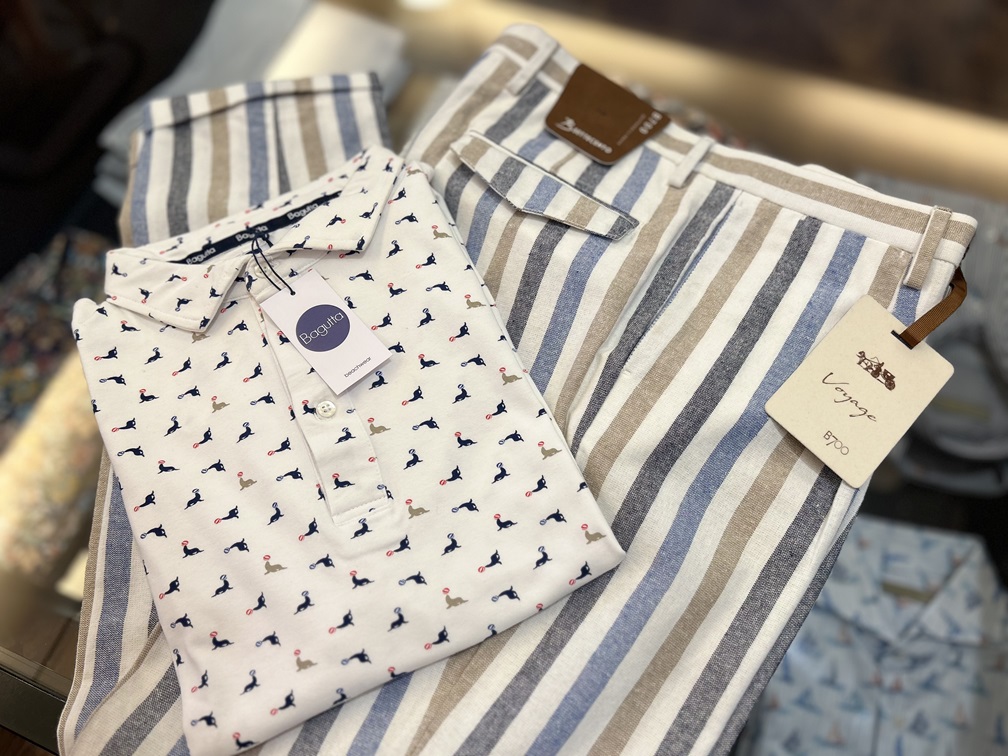 ホワイトのアシカ柄ポロシャツとストライプ柄パンツを組み合わせた夏のコーディネート提案