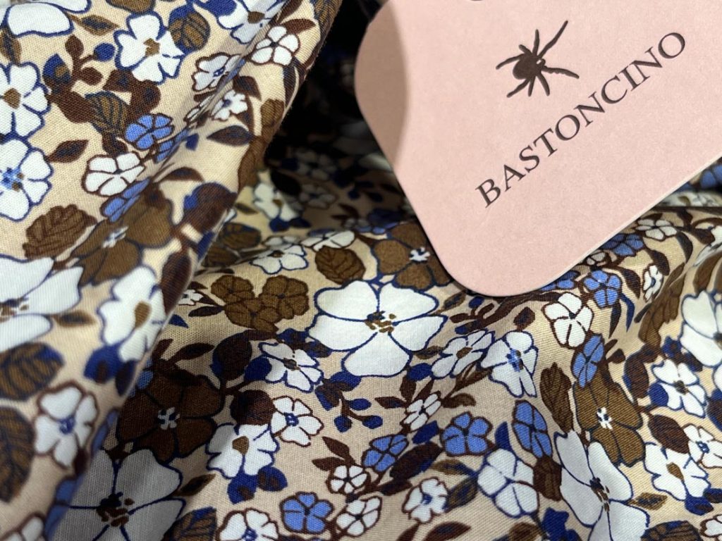 《BASTONCINO（バストンチーノ）》の花柄シャツの生地をクローズアップ。ブルーとブラウンの花柄が美しく、上品な印象。