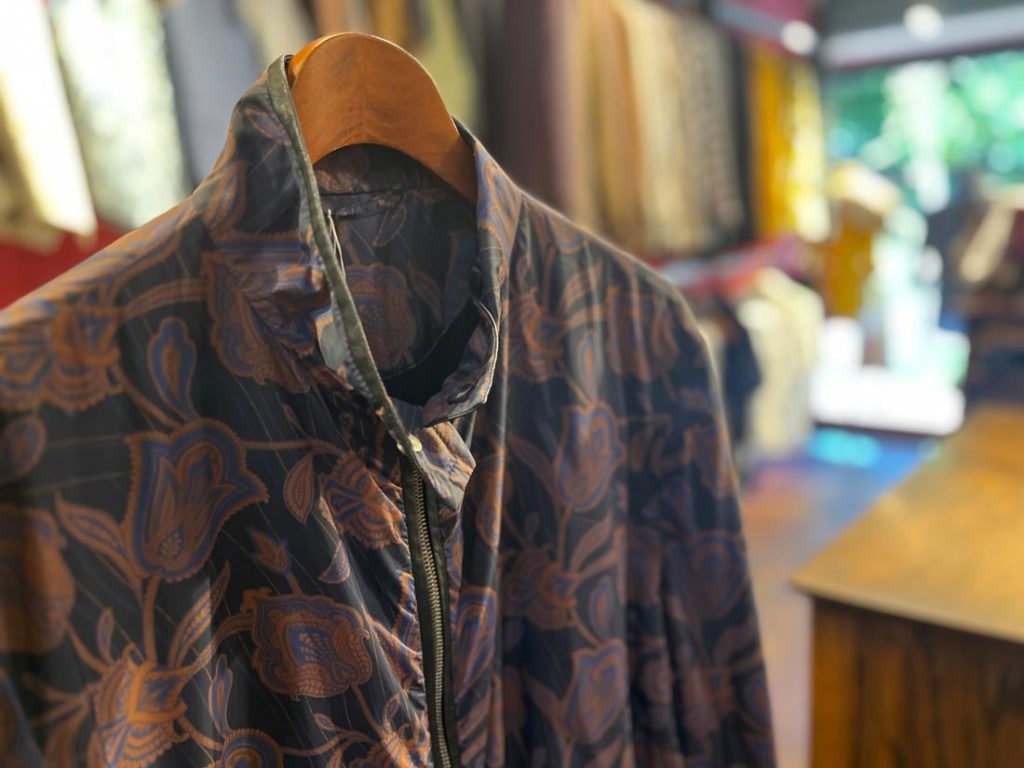 ETROの花柄ジップブルゾン。深みのあるネイビーベースにオレンジブラウンのフラワーパターンが映えるエレガントな秋冬アウター。