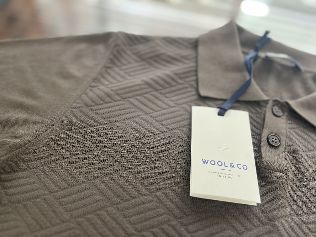 ジャガードの立体感が映えるWOOL&COポロシャツのタグ付きディテール写真