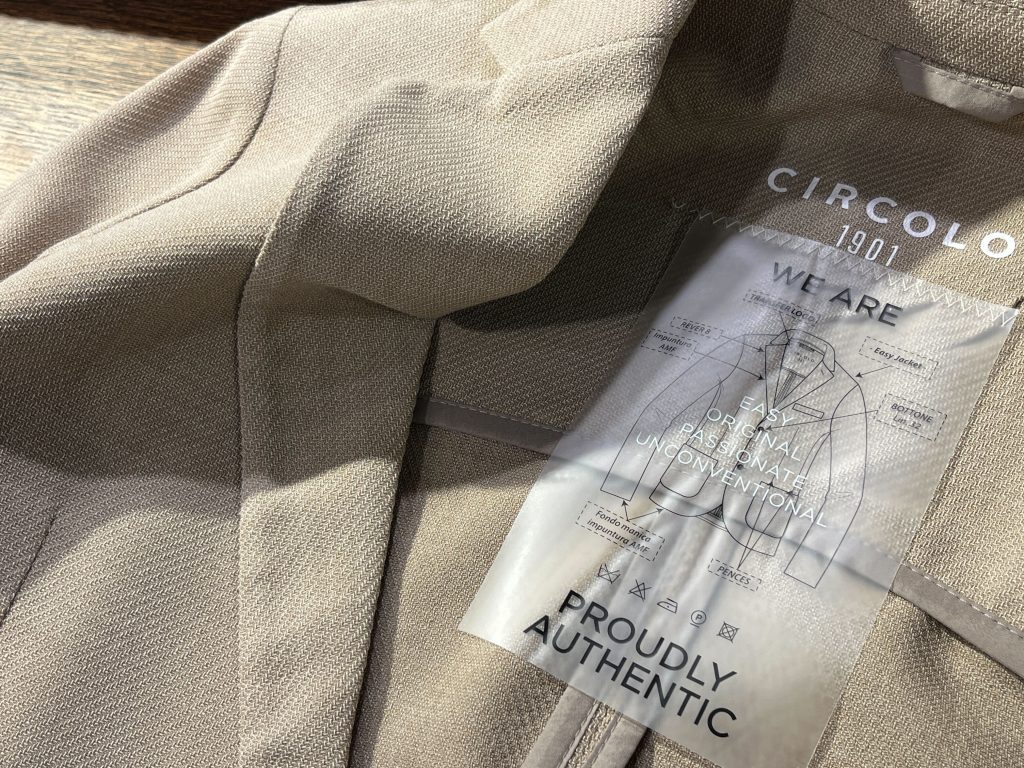 CIRCOLO 1901のベージュジャケットの内タグ。オリジナリティと快適さを追求した新作モデル。