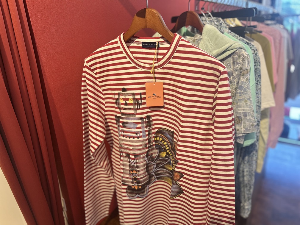 ショップ内でハンガーに掛けられたETRO赤ボーダーカットソー、鮮やかなロボットデザインが際立つ
