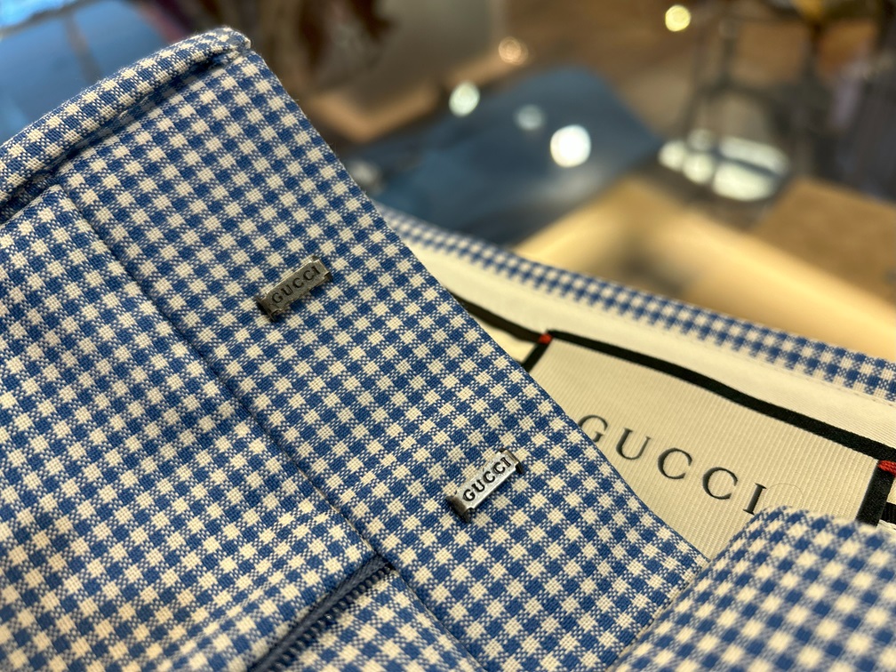GUCCI ギンガムチェックパンツのメタルパーツ刻印ロゴと細かなギンガム柄の質感クローズアップ