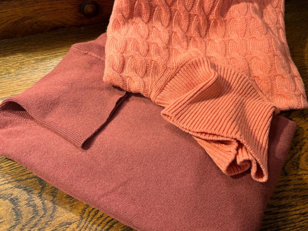 ピンクのケーブル編みニットと赤みがかったピンクのシンプルニット、柔らかく華やかな印象。