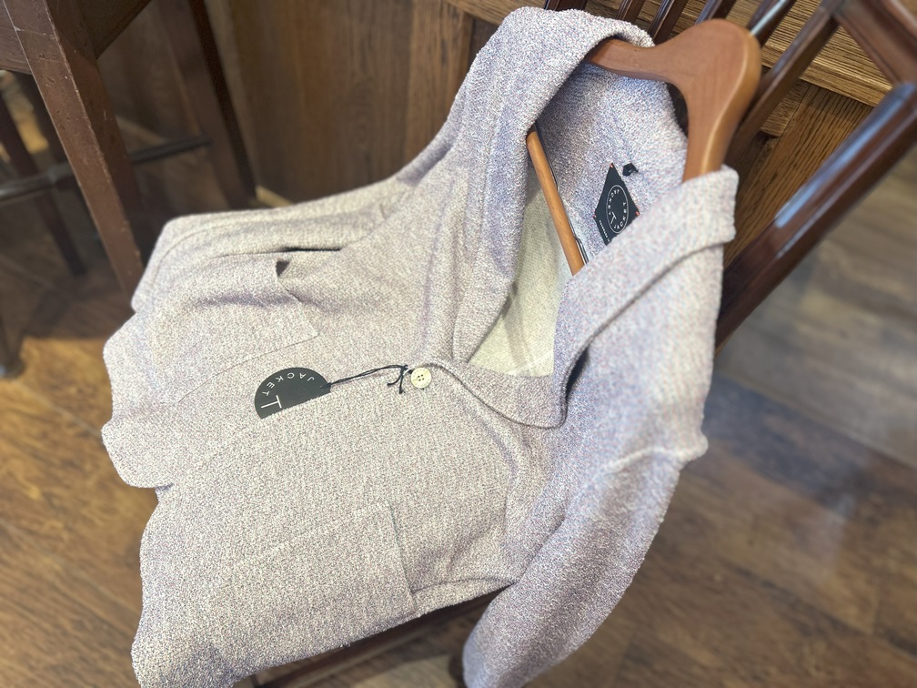 カフェチェアの上に置かれたT JACKETの上品な春夏ニットジャケット