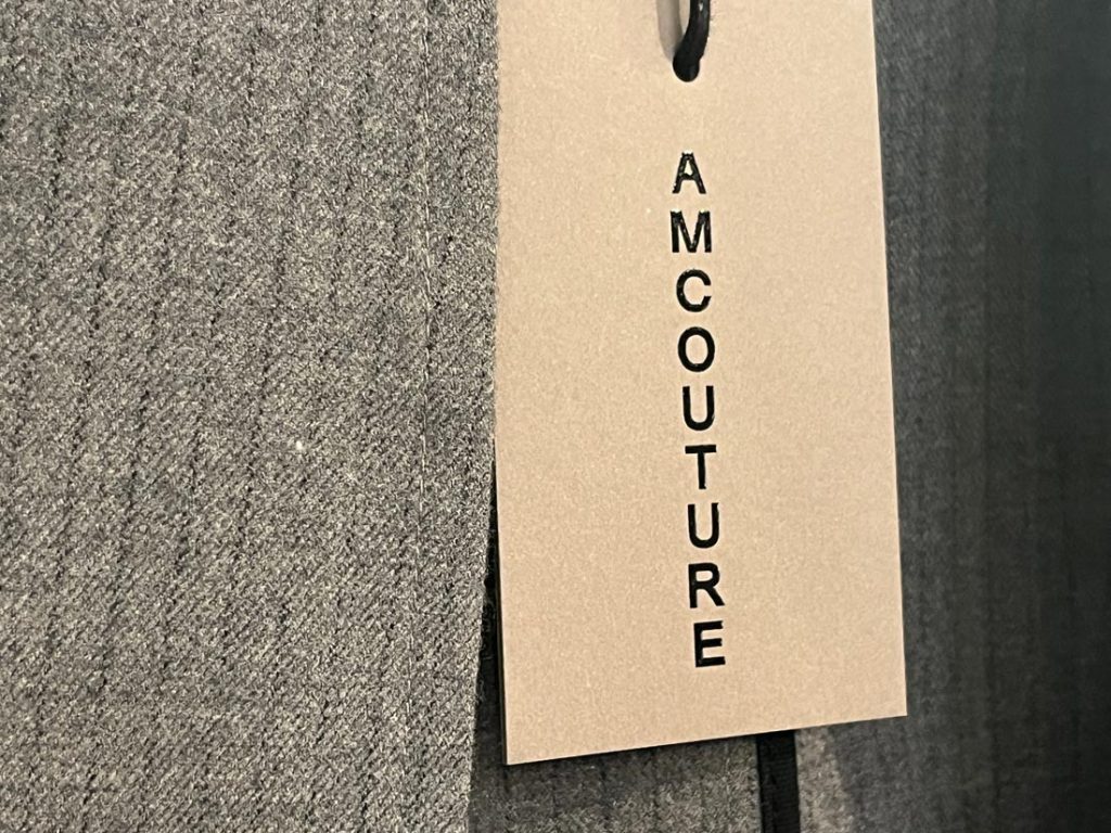 AMCOUTUREのブランドタグがついたグレー生地のクローズアップ