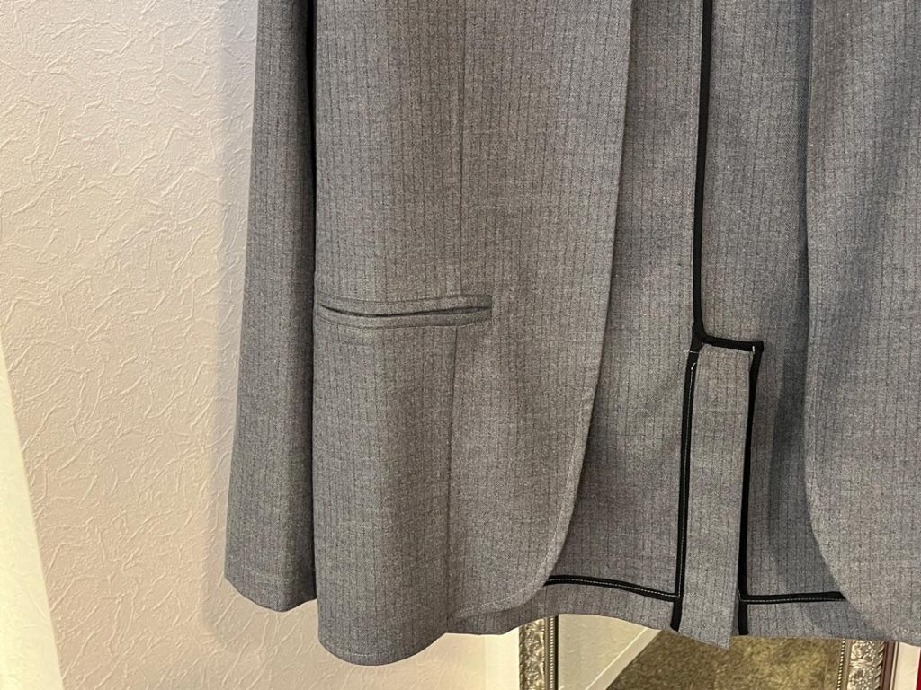 AMCOUTUREグレージャケットの裾とパイピングデザインディテール