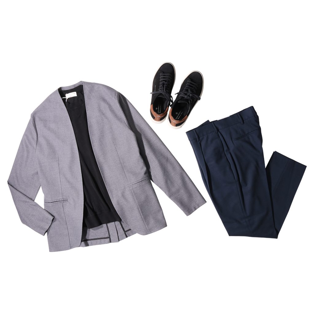 グレーのAMCOUTUREのノーカラージャケットにブラックインナー、ネイビーパンツを組み合わせ、足元は黒スニーカーで仕上げたスマートな大人のカジュアルスタイル。