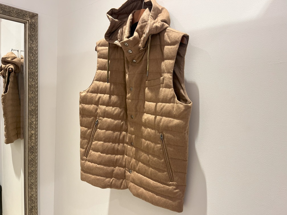 壁にかけられたHERNOのキャメルダウンベスト