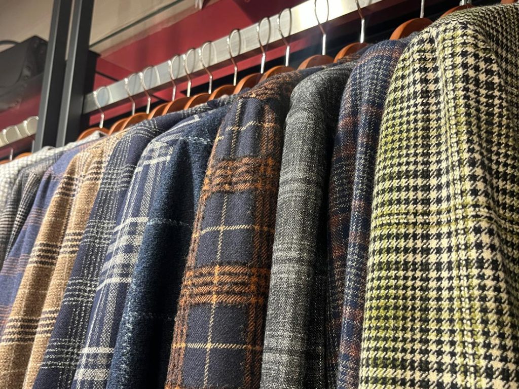 秋冬向けのウール素材チェック柄ジャケットが並ぶディスプレイ。