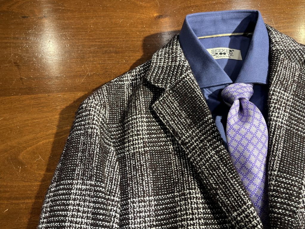 ブラウンのグレンチェック柄ジャケットにネイビーシャツとパープルタイを合わせたスタイリング（円広志さん 着用衣装）
