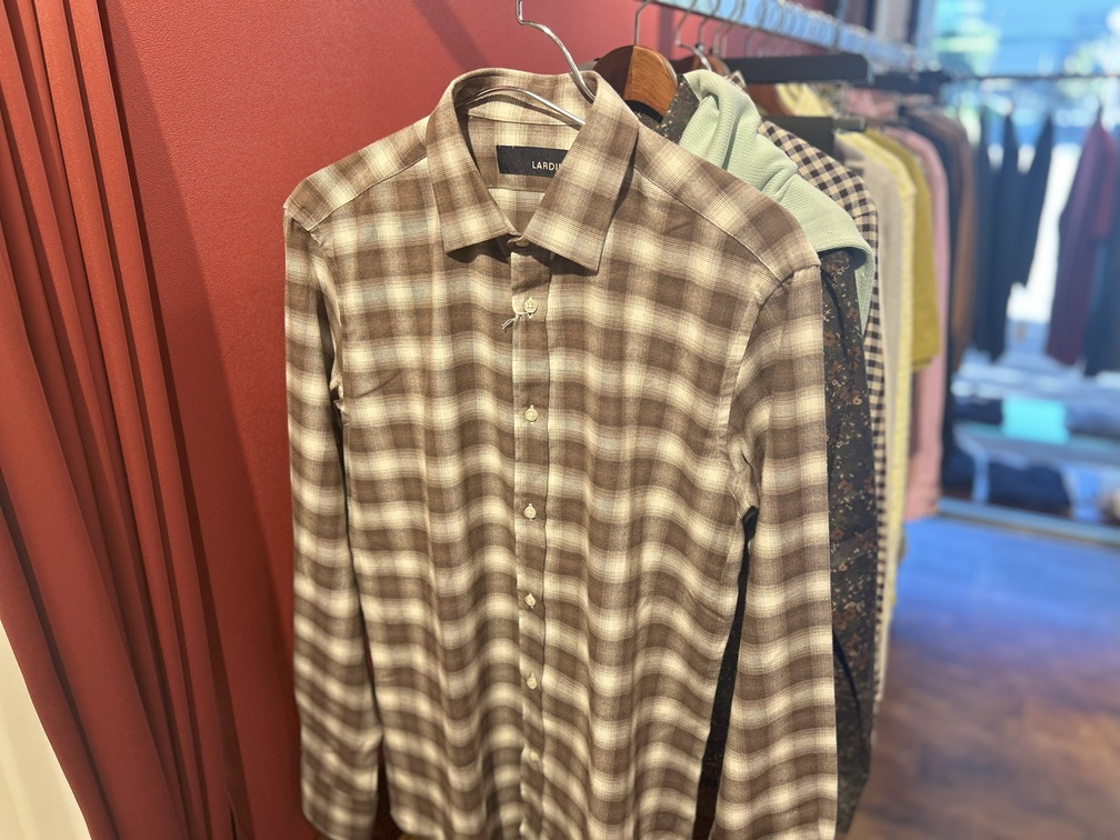 店頭で吊り下げられたブラウンチェックシャツ