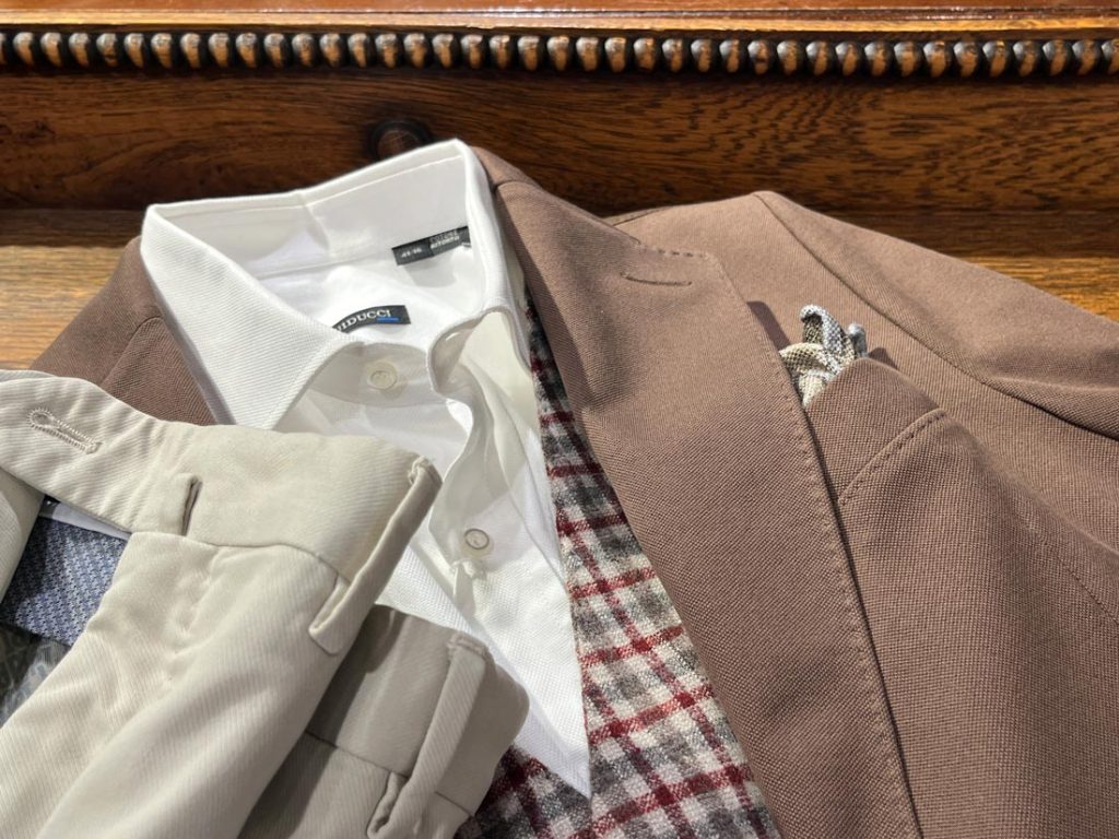 ブラウンジャケットに白シャツとチェック柄ジレを合わせたジャケパンスタイル。ライトベージュのパンツとの組み合わせで秋らしさを演出