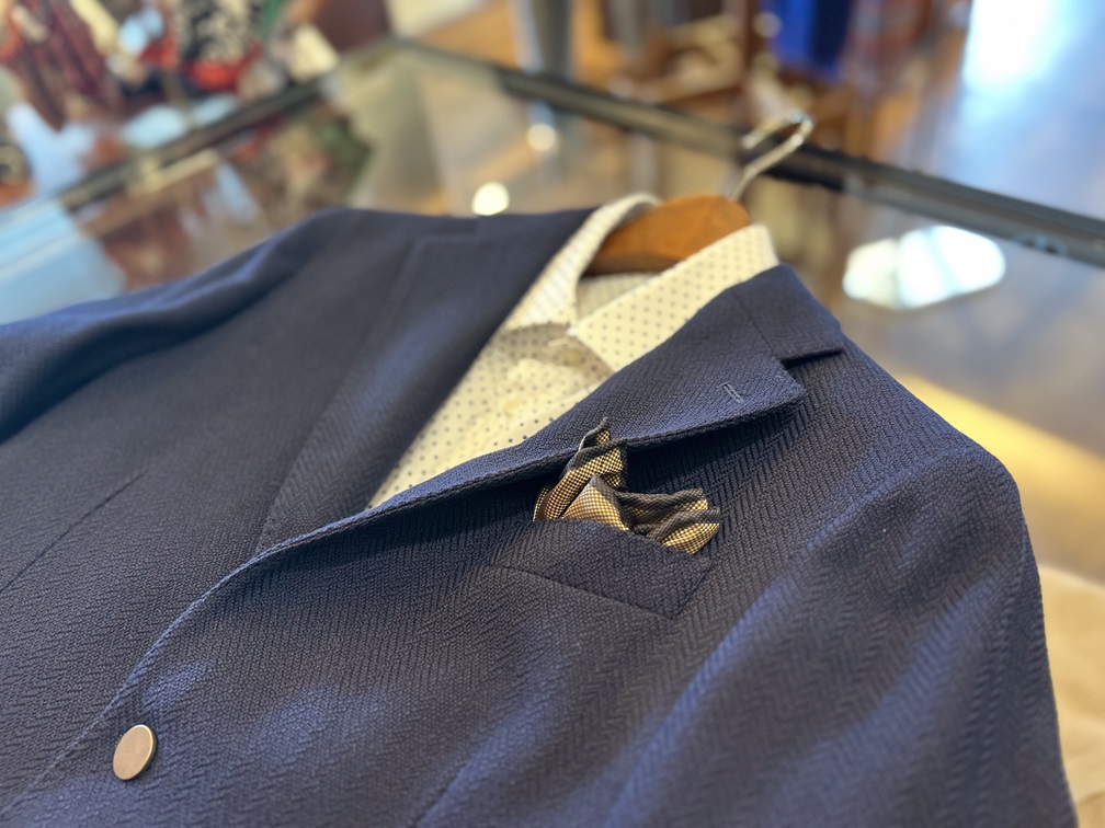 BRERASのネイビーヘリンボーンジャケットにドット柄シャツを合わせた上品なスタイル