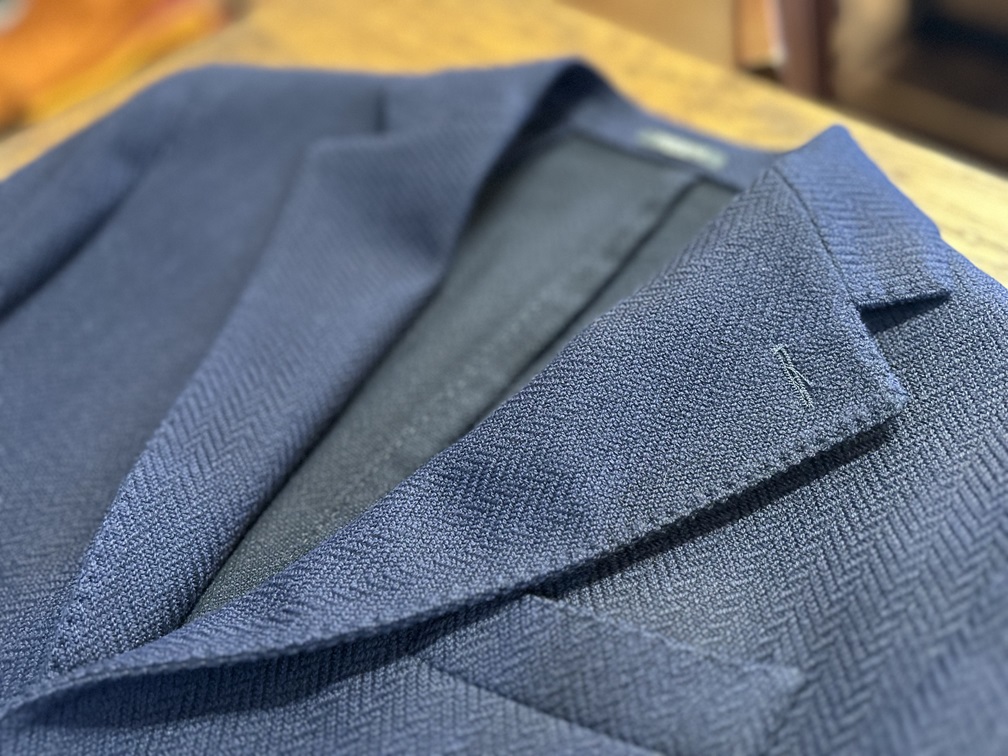 ヘリンボーン織りの美しい質感が際立つBRERASネイビージャケットのラペル部分アップ