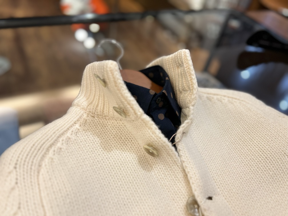 白のニットと合わせたcostumeinコーデュロイドットシャツのネックラインの組み合わせ