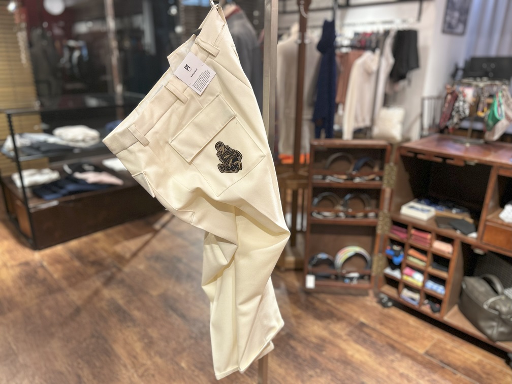 PT TORINO クリームカラーパンツを吊るして展示した様子
