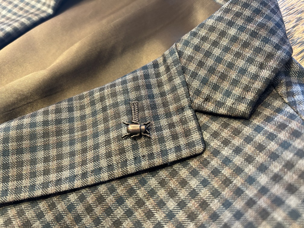 虫モチーフピンが特徴のラペルディテール