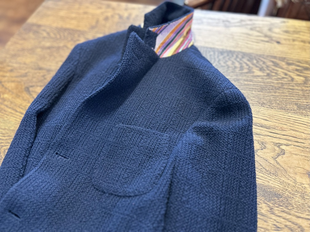 襟裏のストライプが覗くETROジャケットの後ろ姿。上品な遊び心が漂うデザイン。