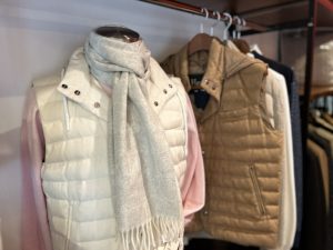 白とブラウンのHERNOライトダウンベストを並べた店頭ディスプレイ。柔らかな色合いが上品な印象を演出。