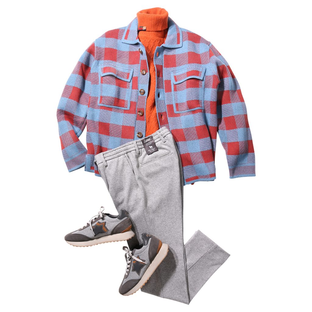 ブルー×レッドのチェック柄ニットブルゾンにオレンジのタートルネックを合わせた大人のカジュアルコーディネート。グレーパンツとスニーカーで軽快にまとめた秋冬スタイル。