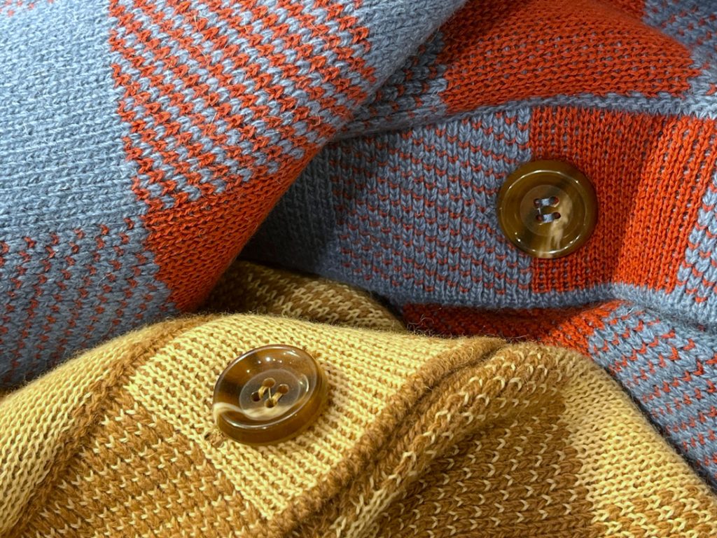 チェック柄ニットブルゾンの立体感ある編地とボタンディテールのアップ